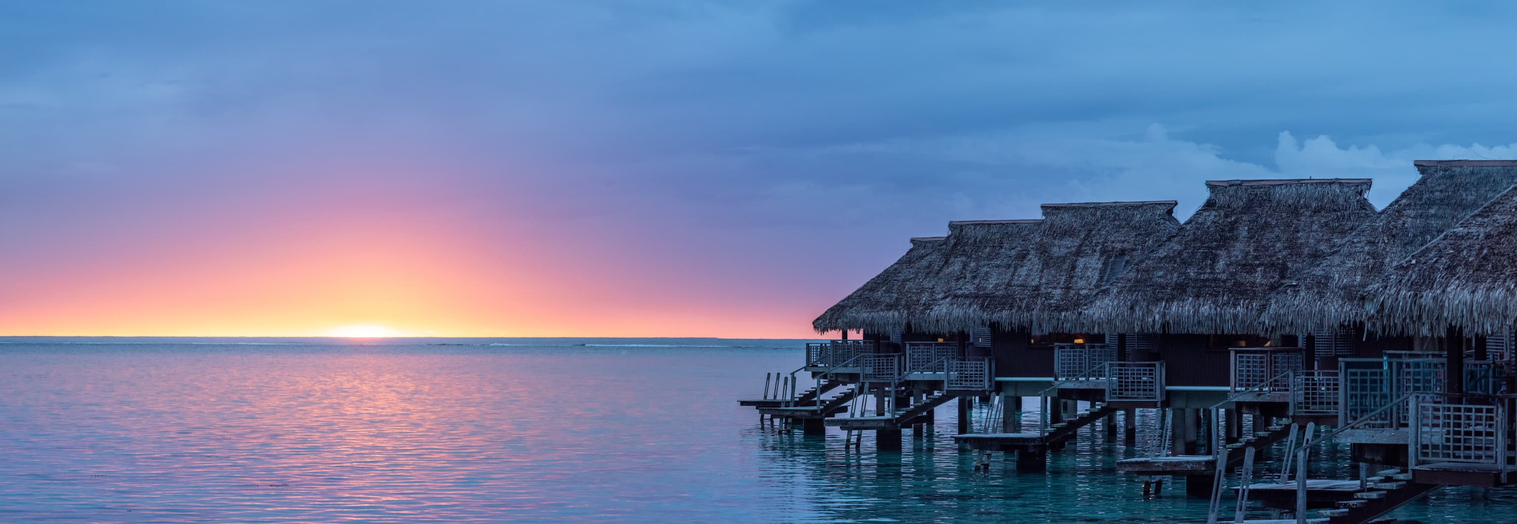 Panorama of overwater villas at sunrise, Bora Bora, French Polynesia — hotel campaign photography by Shot Property