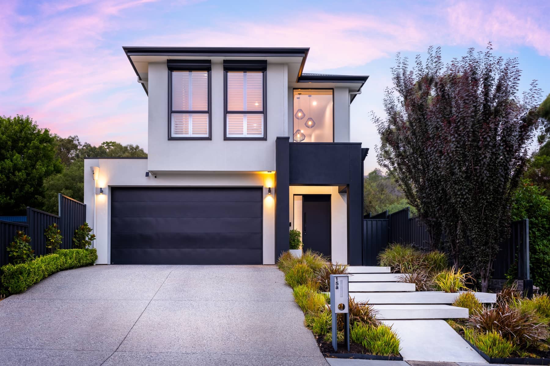 Twilight real estate photography — modern two-storey home glowing at dusk, 15a Perseverance Road